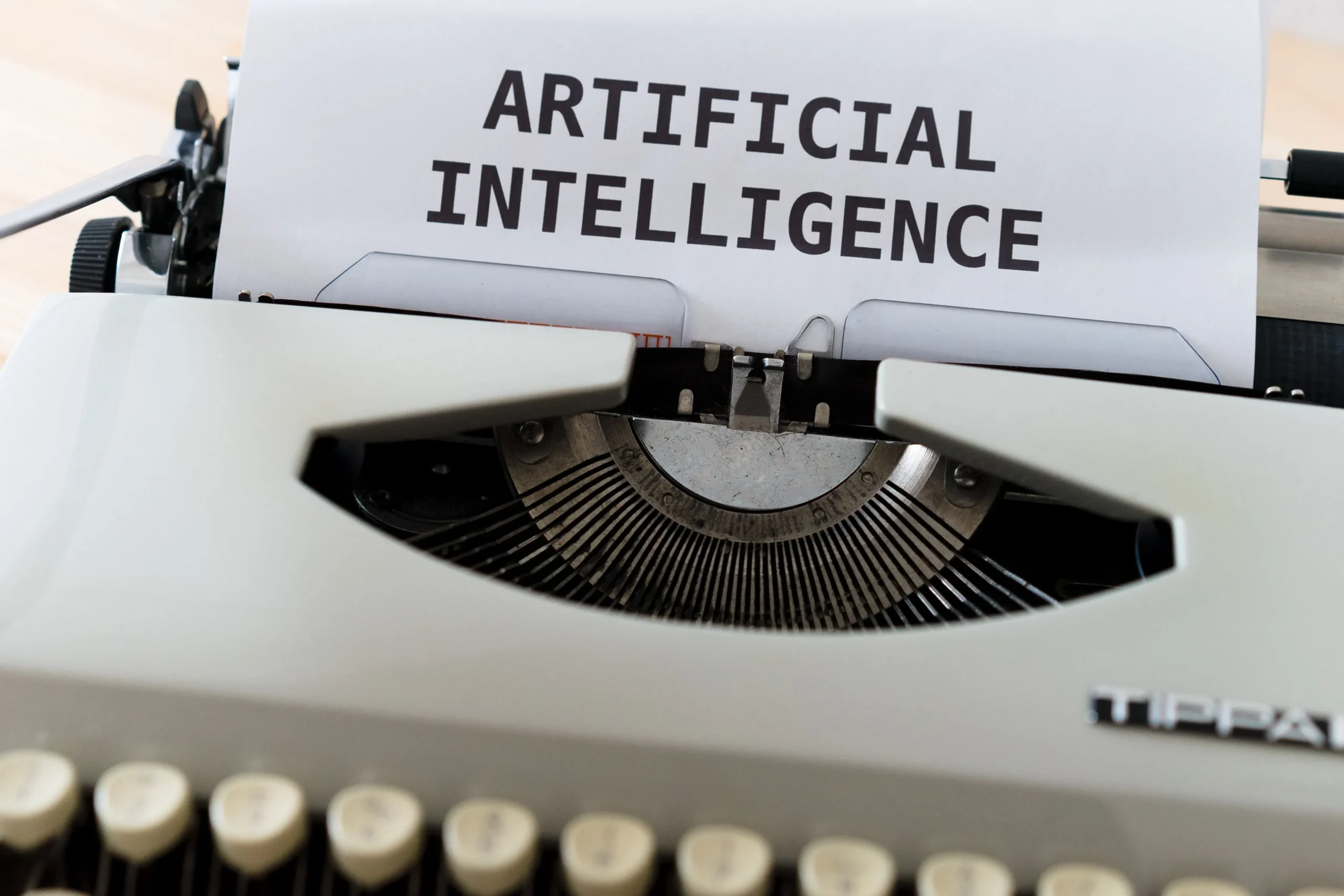 Feuille de papier portant l'inscription Artificial Intelligence insérée dans une machine à écrire pour illustrer la rédaction IA.