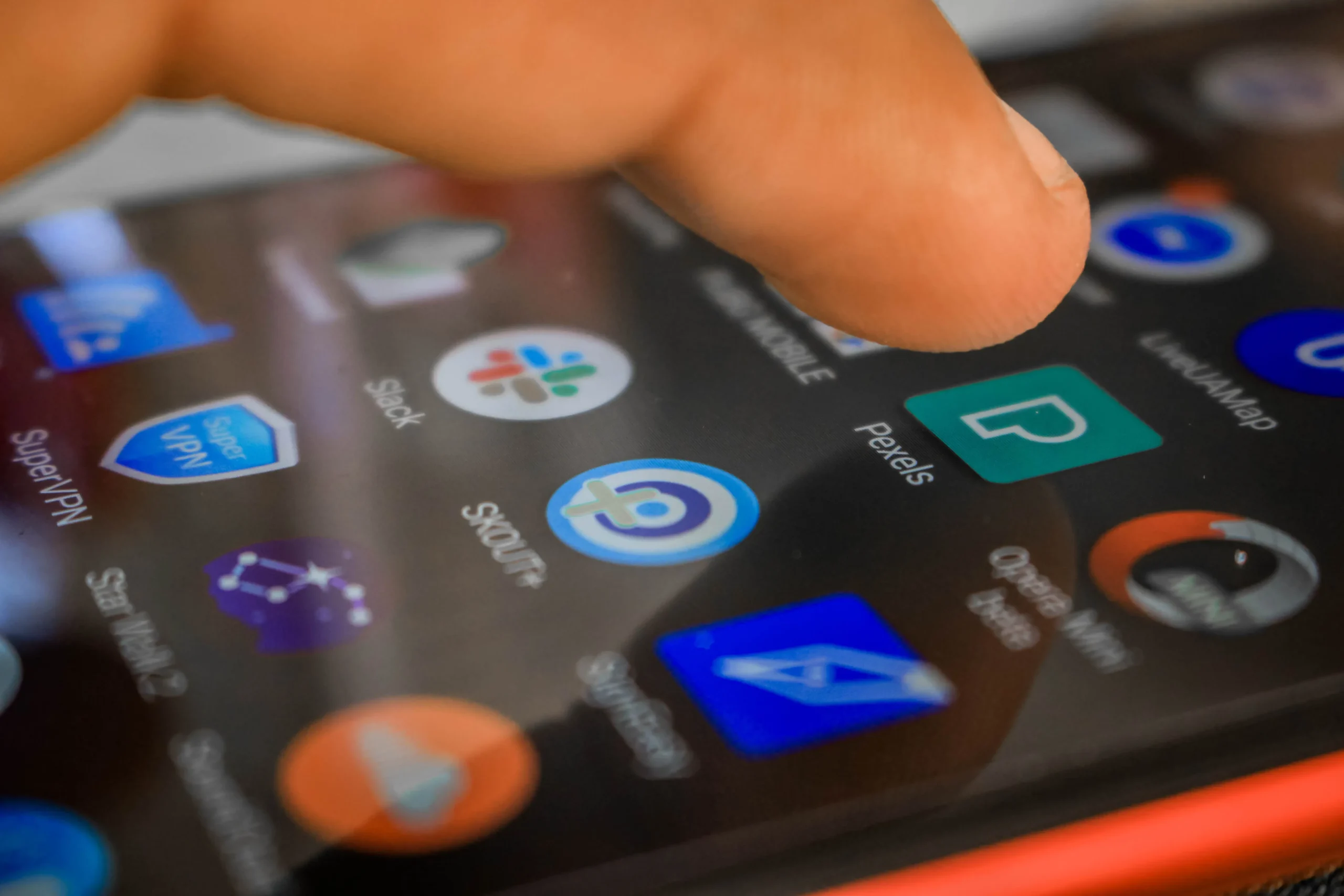 Doigt appuyant sur l'écran tactile d'un smartphone en gros plan.