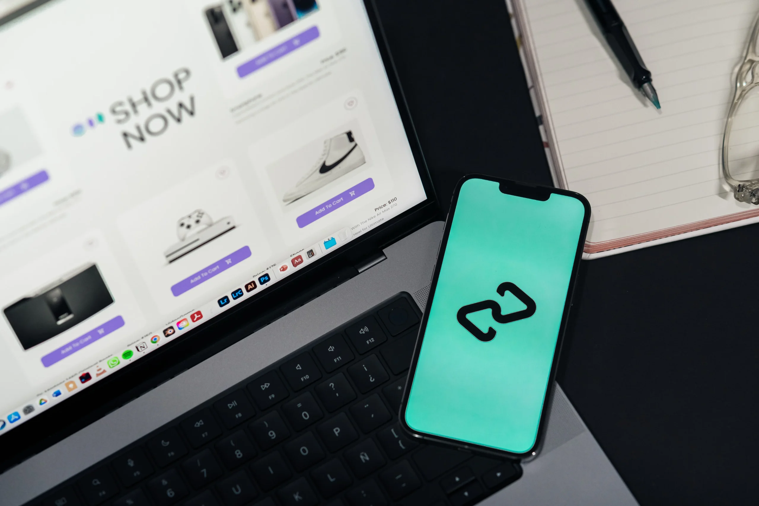 Smartphone posé à côté d'un ordinateur portable affichant une boutique de produits.